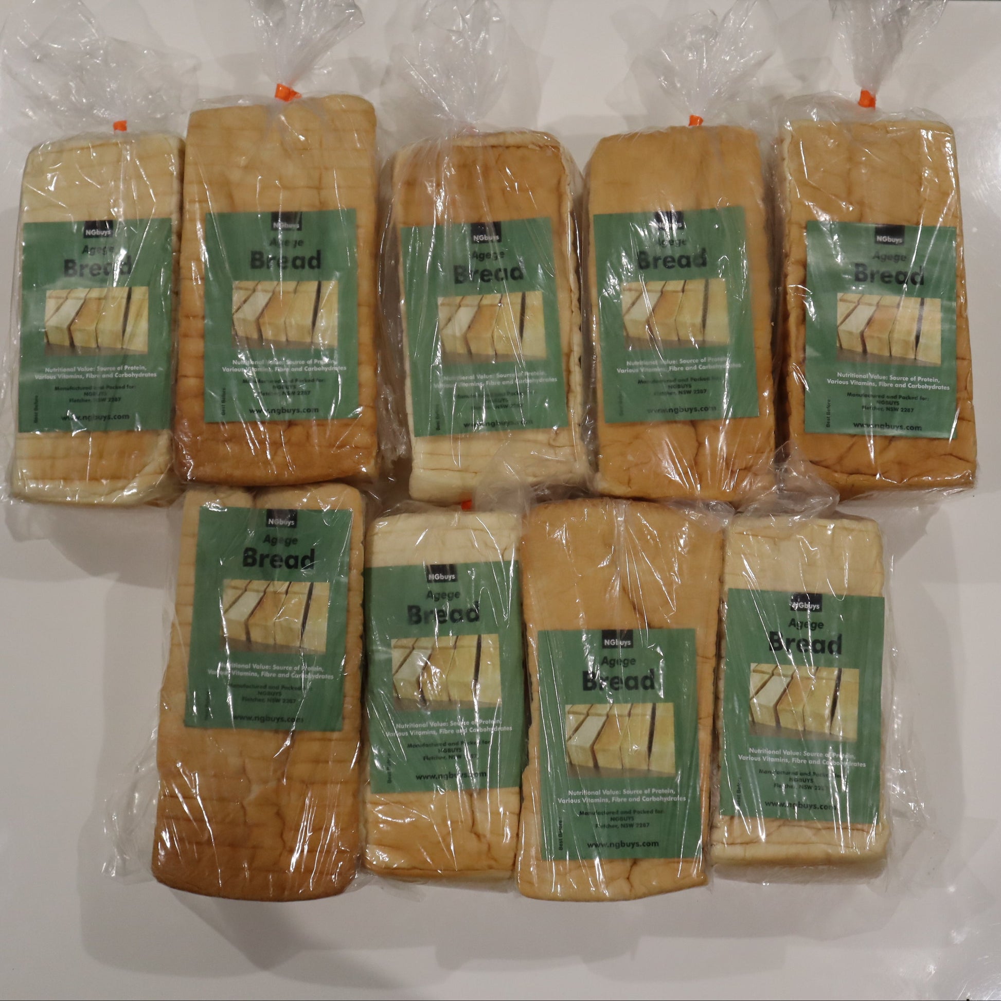 Multiple packages of bread with green labels on a white surface