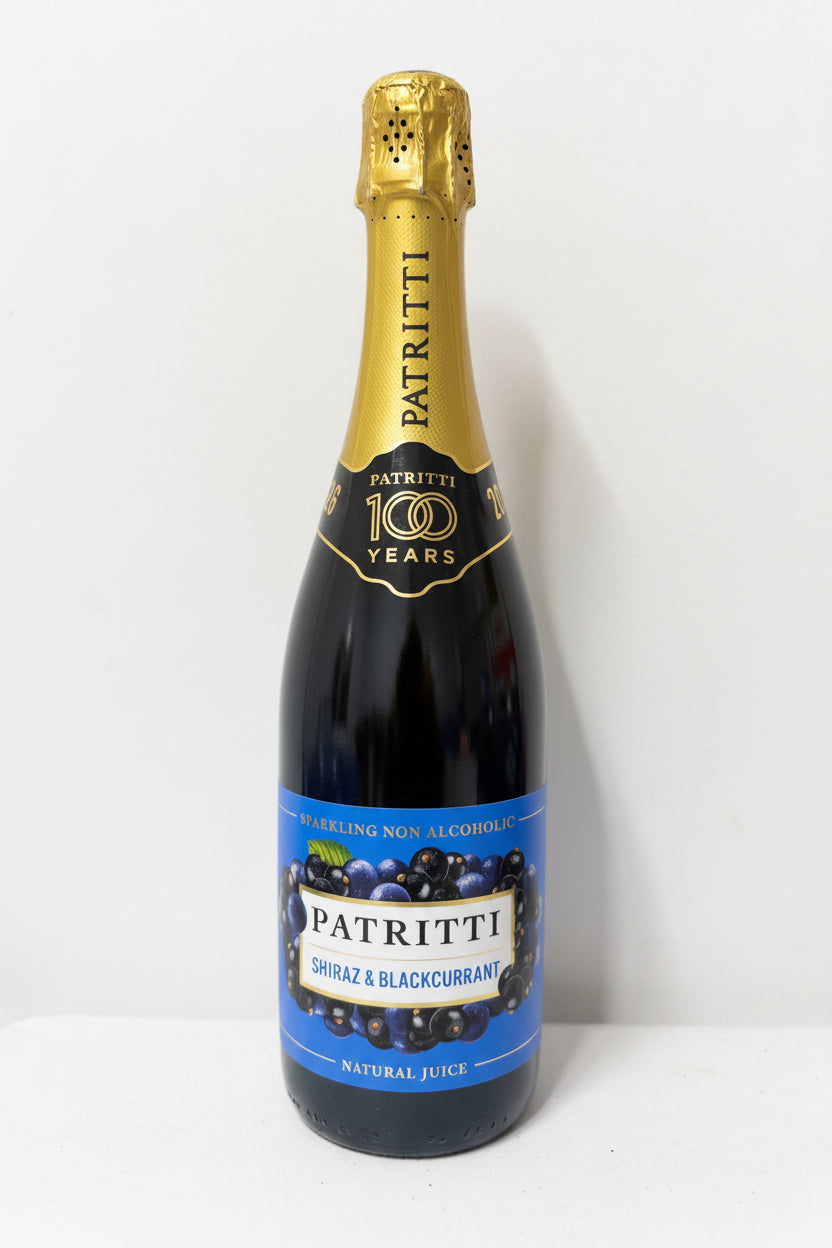 Bottle of Patritti Shiraz & Blackcurrant non-alcoholic juice with gold cap on a white surface.