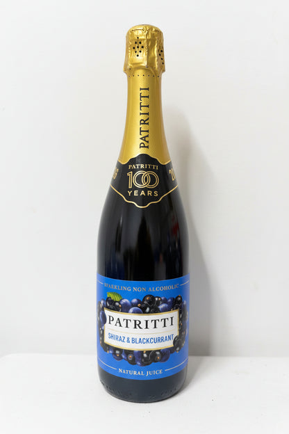 Bottle of Patritti Shiraz & Blackcurrant non-alcoholic juice with gold cap on a white surface.