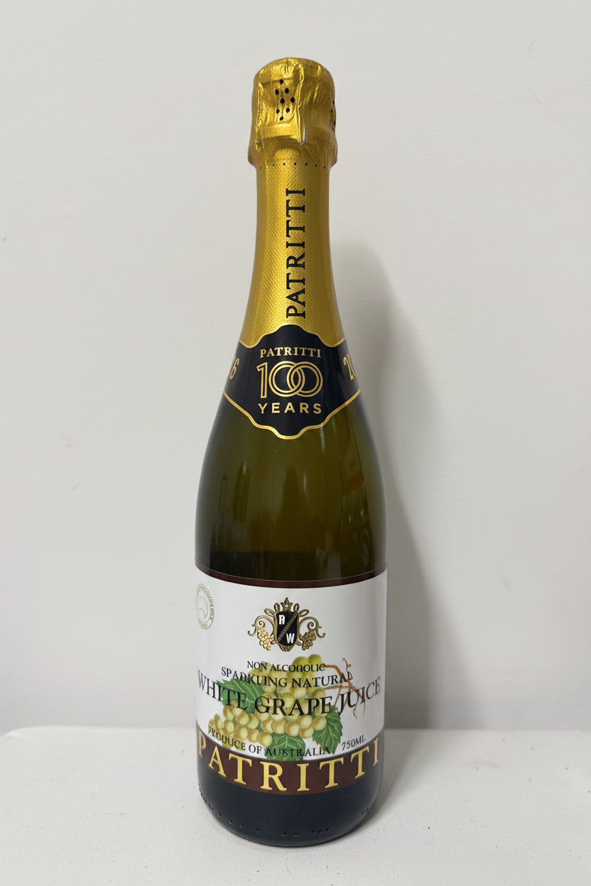 Bottle of Patritti white grape juice with gold foil top on a white background
