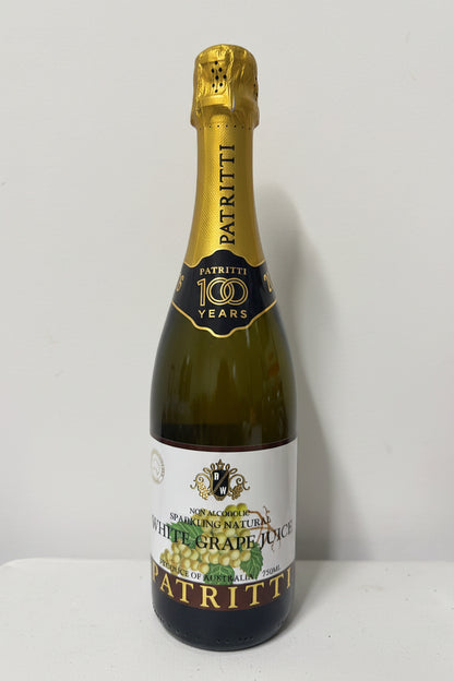 Bottle of Patritti white grape juice with gold foil top on a white background