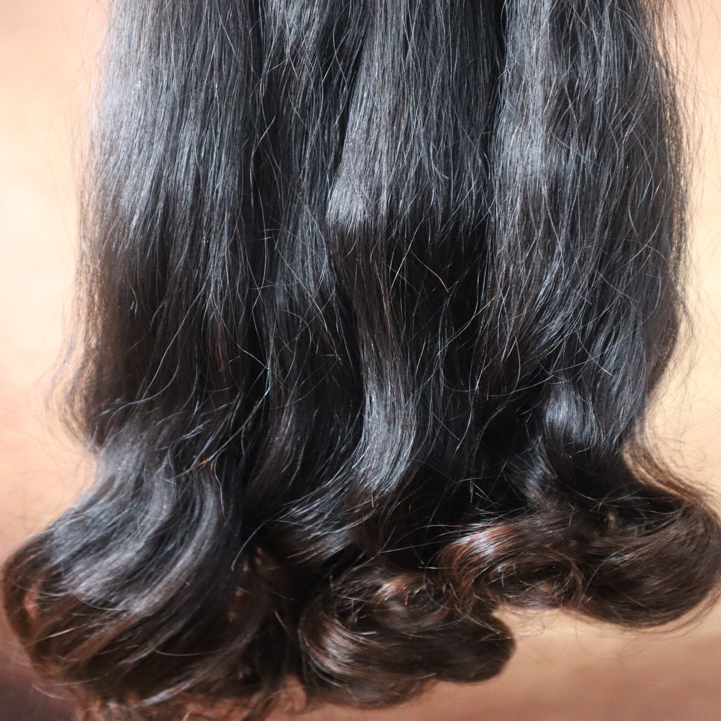 Bundles of black hair on a beige surface