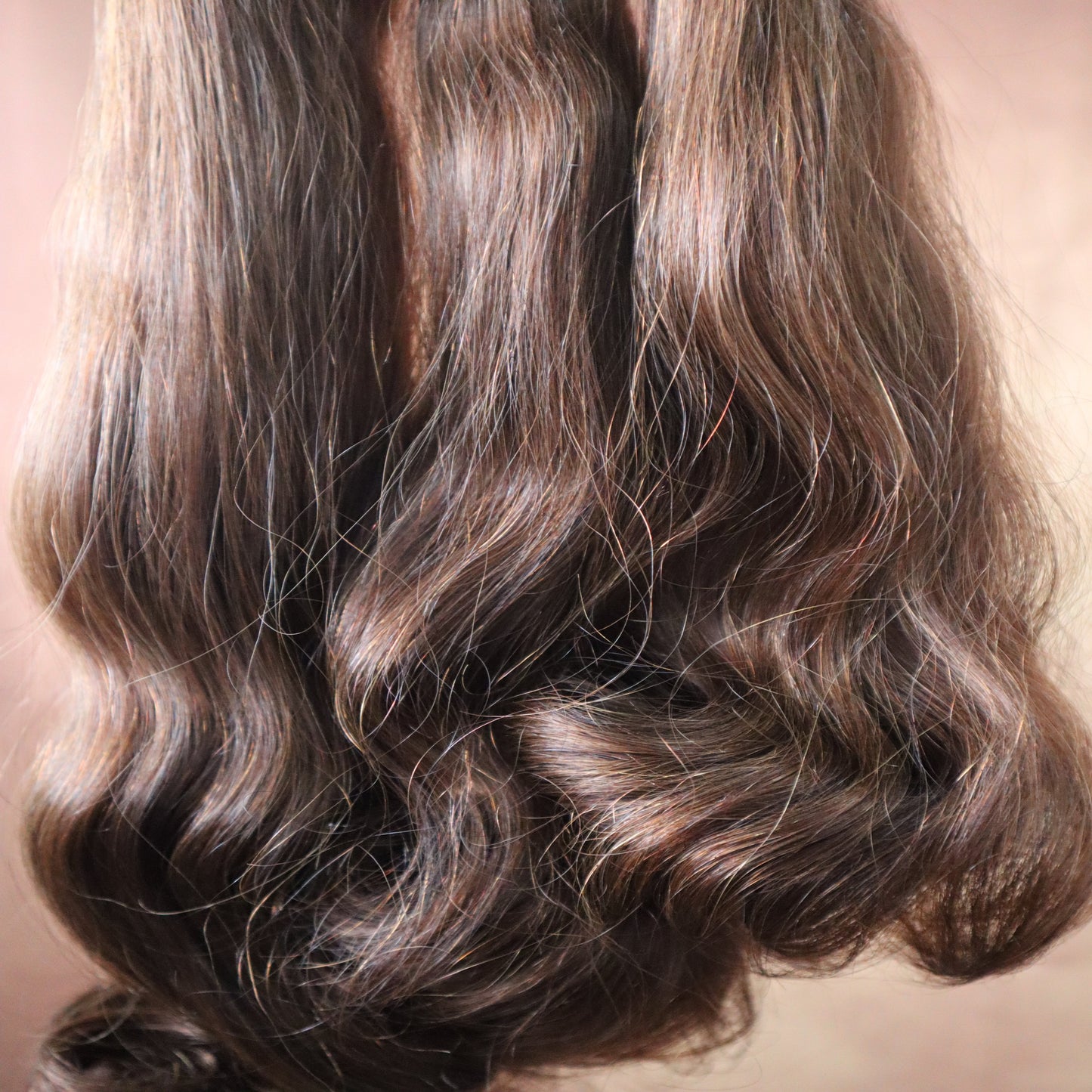 Close-up of wavy brown hair on a neutral background