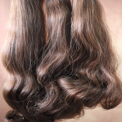 Close-up of wavy brown hair on a neutral background